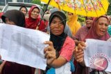 Puluhan ibu rumah tangga keluarga miskin Desa Pusong menyampaikan protes saat aksi demo di kantor Walikota Lhokseumawe, Aceh.Selasa (6/10). Mereka meminta keadilan dan memprotes pemerintah kota yang dinilai tidak tepat menyalurkan dana bantuan rehab rumah warga miskin dari APBK setempat sebesar Rp10 juta hingga Rp15 juta per kepala keluarga. ANTARA FOTO/Rahmad/foc/15.