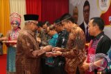 Gubernur Aceh Zaini Abdullah (kiri) menyerahkan bingkisan cincin batu giok kepada perwakilan provinsi dari seluruh Indonesia peserta Pekan Inovasi Perkembangan (PIN) Desa/Kelurahan Nasional dan Gelar Teknologi Tepat Guna (TTG) Nasional XVII Tahun 2015 di Banda Aceh, Aceh, Rabu (7/10). PIN dan TTG nasional ke-17 yang berlangsung hingga 12 Oktober mendatang bertujuan untuk meningkatkan motivasi dan menciptakan inovasi yang mudah dicerna, ekonomis, dan ramah lingkungan. Kegiatan tersebut diikuti 10 kementerian, 34 provinsi, dan 23 kabupaten/kota di Aceh. ANTARA FOTO/Irwansyah Putra/kye/15.