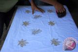 Pekerja melakukan proses pembuatan batik khas Bondowoso motif daun singkong dengan cara teknik cap di Sanggar Lumbung, Tamanan, Bondowoso, Jawa Timur, Sabtu (10/10).  Biaya pembuatan batik dengan teknik cap lebih murah dan proses pembuatannya lebih cepat dibanding teknik batik tulis. Antara Jatim/Seno/15.