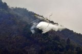 Pesawat jenis Air Tracktor melakukan pemadaman kebakaran di kawasan Taman Nasional Gunung Merbabu, Ampel, Boyolali, Jawa Tengah, Kamis (8/10). Badan Penanggulangan Bencana Daerah (BPBD) Boyolali mengambil langkah untuk mempercepat pemadaman api yang membakar kawasan Taman Nasional Gunung Merbabu dengan sistem bom air atau pemadaman melalui udara menggunakan pesawat jenis Air Tracktor dengan kapasitas 3000 liter air. ANTARA FOTO/ Aloysius Jarot Nugroho/ama/15.