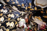  Pekerja mengentas kain batik bordir usai dijemur di industri rumahan kerajinan batik bordir di Pasuruan, Jawa Timur, Senin (12/10). Kerajinan batik yang dikombinasikan dengan bordir dan dijual dengan harga Rp350.000 - Rp400.000 tersebut belum banyak diminati masyarakat karena minimnya promosi. Antara Jatim/Moch Asim/zk/15 