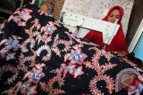  Pekerja menyesaikan pembuatan kain batik bordir  di industri rumahan kerajinan batik bordir di Pasuruan, Jawa Timur, Senin (12/10). Kerajinan batik yang dikombinasikan dengan bordir dan dijual dengan harga Rp350.000 - Rp400.000 tersebut belum banyak diminati masyarakat karena minimnya promosi. Antara Jatim/Moch Asim/zk/15 