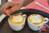 Seorang Barista (pembuat kopi) mencoba membuat Latte Art atau melukis bentuk diatas kopi saat kompetisi Latte Art di Nusa Dua, Bali, Selasa (13/10). Kompetisi Latte Art yang diikuti oleh puluhan Barista tersebut digelar sebagai ajang adu kreatifitas antar Barista untuk membuat bentuk yang inovatif diatas sajian kopi. ANTARA FOTO/Fikri Yusuf/wdy/15