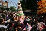 Sejumlah warga berebut Gunungan berisi hasil bumi pada acara Grebeg Suro di Kota Kediri, Jawa Timur, Rabu (14/10). Lima Gunungan hasil bumi yang diperebutkan warga tersebut sebagai simbol kemakmuran dan ucapan terima kasih kepada Tuhan atas curahan rejeki yang berlimpah. Antara Jatim/Prasetia Fauzani/zk/15