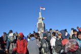 Sejumlah pendaki antre untuk berfoto di tugu penanda ketinggian Puncak Gunung Lawu di perbatasan wilayah Jawa Tengah dan Jawa Timur, Rabu (14/10). Menyambut datangnya tahun baru Jawa 1 Sura bersamaan dengan tahun baru Islam 1 Muharram, ribuan orang pendaki dari berbagai daerah melakukan pendakian puncak Gunung Lawu setinggi 3.265 meter di atas permukaan laut. Antara Jatim/Foto/Siswowidodo/15