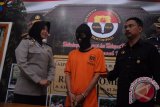 Kasubag Humas Polres Jombang Ipda Dwi Retno (kiri) menunjukan tersangka penjambretan Yudhi Bagus Purwita (tengah) di Mapolres Jombang, Jawa Timur, Kamis (15/10). Tersangka yang masih berstatus PNS Satpol PP (Satuan Polisi Pamong Praja) Kabupaten Jombang, itu dikenakan Pasal 365 KUHP tentang pencurian dan kekerasan dengan ancaman hukuman maksimal 9 tahun penjara. Antara Jatim/Syaiful Arif/zk/15