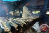 Pedagang melakukan proses pengasapan ikan laut di pasar ikan laut pantai Tambakrejo, Blitar, Jawa Timur, Jum'at (16/10). Pedagang mengaku jika dalam dua minggu terakhir produksi ikan laut asap meningkat hingga 50 persen menjadi 100 ekor per harinya akibat hasil tangkapan nelayan yang melimpah. Antara Jatim/Irfan Anshori/zk/15