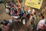 Sejumlah warga antre air bersih bantuan dari Brimob Porong Sidoarjo di desa Candibinangun, Sukorejo, Pasuruan, Jawa Timur, Kamis (22/10). Bakti sosial bantuan 16.000 liter air bersih tersebut dalam rangka HUT ke 70 Brimob sekaligus untuk membantu warga yang dilanda krisis air bersih. Antara Jatim/Moch Asim/zk/15