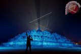 Pengunjung berfoto dengan latar Candi Borobudur yang disinari cahaya biru saat acara HUT Persatuan Bangsa Bangsa (PBB) ke-70 bertajuk 'Terangi Dunia dengan Biru' di Candi Borobudur, Magelang, Jawa Tengah, Sabtu (24/10). Penyinaran Candi Borobudur dengan cahaya biru dalam rangkaian HUT PBB ke-70 yang jatuh pada tanggal 24 Oktober itu menjadi simbol pelita menuju masa depan yang lebih baik serta sebagai relfeksi pencapaian historis PBB dalam pembangunan, penjagaan keamanan dan perlindungan hak asasi manusia. ANTARA FOTO/Andreas Fitri Atmoko/wdy/15.