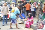 Seorang pengemis paruh baya duduk di trotoar menerima uang dari seorang pemuda yang akan melaksanakan shalat Jumat di Masjid Sabilal Muhtadin, Banjarmasin (23/10. Warga Alalak ini membiayai hidupnya seorang diri dengan cara mengemis.(Shasa/Yunita/e)