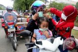 Aktivis Inong Aceh membagi dan memakaikan masker kepada warga pengguna jalan di Simpang Lima, Banda Aceh, Aceh, Senin (26/10). Pembagian ribuan masker kepada warga sebagai bentuk protes atas tindakan pembakaran hutan di wilayah Sumatera dan Kalimantan yang mengakibatkan kabut asap hingga mengganggu kesehatan. ANTARA FOTO/Irwansyah Putra/ama/15.