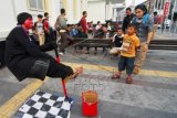 Seorang seniman jalanan memerlihatkan trik sulap di jalanan Merdeka Bandung, Jawa Barat, Senin (26/10). Aksi sulap tersebut menjadi salah satu daya tarik pengunjung yang berpergian ke kawasan Gedung Merdeka. ANTARA FOTO/Agus Bebeng/ama/15