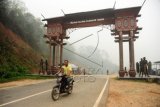 Seorang pengendara motor memasuki pintu gerbang perbatasan Trans Kalimantan di Kabupaten Ketapang, Kalbar, Senin (26/10). Pintu gerbang perbatasan Trans Kalimantan tersebut menghubungkan jalur darat antara provinsi Kalimantan Barat dan Kalimantan Tengah. ANTARA FOTO/Jessica Helena Wuysang/aww/15.