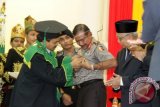 Rektor Universitas Islam Negeri Ar Raniry, Prof. Dr. Farid Wajdi Ibrahim, MA (kiri) menyematkan pin kepada Kapolri Jenderal Badrodin Haiti (tengah) disaksikan Gubernur Aceh, Zaini Abdullah (kanan) di Universitas Islam Negeri (UIN) Ar Raniry, Banda Aceh, Kamis (29/10). Kehadiran Kapolri Jenderal Badrodin Haiti di Aceh dalam rangka memenuhi undangan peringatan hari jadi ke 52 UIN Ar Raniry dan memberikan orasi ilmiah bertajuk Mengendalikan Dizzying Effects Perubahan Dalam Perspektif Keamanan Untuk Kesejahteraan. ANTARA FOTO/Ampelsa/foc/15.