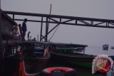 Beberapa pemilik klotok taksi menunggu penumpang di dekat Dermaga Penyeberangan feri Sungai Barito Alalak Selatan, Kamis 29/10. Meski perairan Sungai Barito diselimuti asap tebal namun taksi klotok jurusan Pulau Kembang dan sekitarnya itu tetap beroperasi untuk memenuhi kebutuhan ekonomi keluarga.(Foto Feberian Akbar Giffari/Dwiki Dharmawan/e)