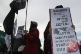 Mahasiswa Hizbut Tahrir membentangkan poster dan spanduk saat aksi di Bundaran Simpang Lima, Banda Aceh, Kamis (5/11). Mereka menyerukan kepada pemerintah Indonesia menghentikan sistem sekuler dengan menggantikan sistem Islam dengan cara penetapan syariat islam secara kaffah. ACEH.ANTARABNEWS.COM/Ampelsa/15