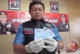 Petugas Polres Kediri menunjukkan KTP palsu dalam gelar perkara di mapolres setempat, Jumat (6/11). Polisi menahan tiga pelaku sebagai pencair korban serta pembuat KTP. Tarif yang dipatok untuk KTP serta surat berharga mulai Rp100 ribu sampai Rp500 ribu per lembar. Antara Jatim/Foto/Asmaul Chusna/15