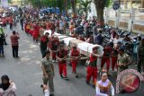 Puluhan warga mengangkat kayu jati yang diberi nama 'Mbah Balok', sepanjang 17 meter dengan diameter 45 centimeter di Kabupaten Bojonegoro, Jawa Timur, dari tempat penimbunan kayu jati (TPK) ke alun-alun, Sabtu (7/11). Pemerintah kabupaten (pemkab) menjadikan kayu jati temuan di Bengawan Solo, pada 1994, sebagai monumen yang menandakan daerah setempat merupakan penghasil kayu jati terbaik di dunia. Antara Jatim/Foto/Slamet Agus Sudarmojo/15. 