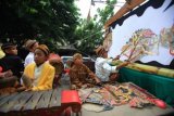 Dalang bocah menampilkan aksinya bermain wayang saat mengikuti kirab wayang bertajuk Semar Sang Pamomong di Jalan Slamet Riyadi Solo, Jawa Tengah, Jumat, (6/11). Acara tersebut digelar dalam rangka memperingati pengakuan UNESCO atas wayang Indonesia sebagai Warisan Budaya Nonbenda Umat Manusia. ANTARA FOTO/Maulana Surya/aww/15.