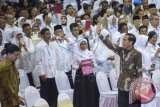 Presiden Joko Widodo (kanan) melambaikan tangan ke arah para guru yang hadir pada acara puncak Peringatan Hari Guru Nasional ke-21 Tahun 2015 di Istora Senayan, Jakarta, Selasa (24/11). Dalam acara bertema Guru Mulia karena Karya tersebut Presiden Joko Widodo memberikan Satyalancana Pendidikan kepada sejumlah guru dan tenaga kependidikan atas pengabdian dan prestasi mereka. ANTARA FOTO/Widodo S. Jusuf/wdy/15.