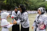 Seorang murid menghadiahkan bunga kepada gurunya sebagai simbul kecintaan dan penghargaan mereka usai  upacara  memperingati Hari Guru Nasional (HGN) ke 70 di SDN 1 Banda Aceh, Rabu (25/11). Peringatan Hari Guru Nasional yang berlangsung haru di daerah itu, selain pemberian bunga dan mennyanyikan lagu guru pahlawan tanda jasa. ACEH.ANTARANEWS.COM/Ampelsa/15