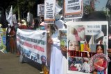 Sejumlah aktivis Muslimah Hizbut Tahrir Indonesia (MHTI) membawa sejumlah poster yang berisi tuntutan penghentian pengiriman TKI ke sejumlah negara. MHTI berdemonstrasi menyuarakan tuntutan tersebut di bundaran DPRD Jember. Antara Jatim/Zumrotun Solichah/zk/15