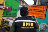 Petugas Suku Dinas Pelayanan Pajak Kota Administrasi Jakarta Utara memasang papan penunggak Pajak Bumi Bangunan dan Pedesaan Perkotaan (PBB-P2) di kantor PT Dok dan Perkapalan Kodja Bahari (Persero), Tanjung Priok, Jakarta, Senin (23/11). Perusahaan itu tercatat menunggak pajak hingga Rp11 miliar. (ANTARA FOTO/M Agung Rajasa)