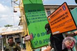 Petugas Suku Dinas Pelayanan Pajak Kota Administrasi Jakarta Utara memasang papan penunggak Pajak Bumi Bangunan dan Pedesaan Perkotaan (PBB-P2) di kantor PT Dok dan Perkapalan Kodja Bahari (Persero), Tanjung Priok, Jakarta, Senin (23/11). Perusahaan itu tercatat menunggak pajak hingga Rp11 miliar. (ANTARA FOTO/M Agung Rajasa)