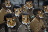 Sejumlah siswa SD memakai topeng harimau sumatera saat program 'Trauma Healing' setelah bencana kebakaran hutan dan asap di Desa Paduran, Pulau Pisang, Kalimantan Tengah, Sabtu (28/11). Kegiatan yang diprakarsai oleh Greenpeace itu bertujuan untuk membantu memulihkan kondisi psikis dan mental masyarakat yang terdampak bencana asap dan kebakaran hutan. ANTARA FOTO/HO/ Greenpeace/Ardiles Rante/pras/15.