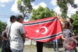 Mantan Kombatan Gerakan Aceh Merdeka (GAM) menurunkan bendera Bintang Bulan usai dikibarkan selama sekitar tiga jam dalam rangka memperingati Milad GAM  di Kantor Mes Wali Nanggroe Aceh, Banda Aceh, Kamis (3/12). Penurunan bendera Bintang Bulan dilakukan setelah polisi melakukan negoisasi dengan mantan kombatan GAM terkait dengan kesepakatan bersama pihak petinggi mantan GAM, pemerintah Aceh dan aparat keamanan yang menyebutkan tidak ada pengibaran bendera bintang bulan menyambut Milad GAM 4 Desember. ACEH.ANTARANEWS.COM/Ampelsa/15 
