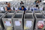 Sejumlah pekerja menempelkan stiker Tempat Pemungutan Suara (TPS) di kotak suara di Kantor KPUD Sidoarjo, Jawa Timur, Rabu (2/12). KPU Kabupaten Sidoarjo mempersiapkan lebih dari 2.500 kotak suara yang akan disebar di 2.463 tempat pemungutan suara (TPS) di 18 kecamatan se-Kabupaten Sidoarjo sebagai persiapan pilkada serentak pada 9 Desember mendatang. (ANTARA FOTO/Umarul Faruq)