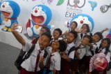 Sejumlah siswa berfoto selfie dengan latar patung Doraemon di arena Pameran 100 alat rahasia Doraemon di Grand City Mall Surabaya, Senin (7/12). Pameran digelar selama 70 hari, mulai 7 Desember 2015 hingga 14 Februari 2016 untuk menyambut liburan dan tahun baru. Foto Antara Jatim/Fiqih Arfani/zk/15