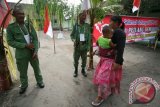 Petugas keamanan lengkap dengan atribut repelika senjata berjaga di depan Tempat Pemungutan Suara (TPS) Pilkada di Desa Srikaton, Kabupaten Kediri, Jawa Timur, Rabu (9/12). Tempat pemungutan suara bertema 'Pejuang Demokrasi' tersebut mewajibkan seluruh petugas TPS berkostum pejuang guna menarik minat warga untuk menggunakan hak pilihnya pada pilkada. Antara Jatim/Prasetia Fauzani/zk/15