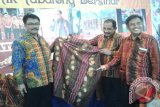 Tanjung, 12/12 - Batik Tanjung Bersinar dengan berbagai motif khusus mulai dari buah langsat, Burung Enggang hingga ukiran khas Dayajk ikut dipamerkan pada Tabalong Expo yang digelat mulai hari ini hingga 18 Desember 2015. Sekretaris Daerah Kabupaten Tabalong Abdul Muthalib Sangaji bersama Kepala Badan Kesbangpol Zulfanoor memperlihatkan motif Batik Tanjung Bersinar di stand milik Dekranasda Kabupaten Tabalong. Foto:Antara/Herlina Lasmianti