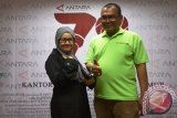 Humas Universitas Narotama Surabaya Evy Retno (kiri) Wulan bersama Kepala LKBN Antara Biro Jatim Akhmad Munir (kanan) sebagai ucapan selamat hari ulang tahun ke-78 LKBN Antara di Graha Antara Biro Jatim, Surabaya, Senin (14/12). Antara Jatim/Zabur Karuru/15