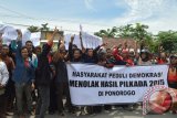 Massa yang tergabung dalam Masyarakat Peduli Demokrasi Kabupaten Ponorogo melakukan aksi demo di depan kantor Komisi Pemilihan Umum (KPU) Kabupaten Ponorogo, Jawa Timur, Selasa (15/12). Mereka menuding terjadi pelanggaran saat Pilkada Bupati Ponorogo 9 Desember lalu, sehingga mereka menuntut KPU melakukan pencoblosan ulang dan menunda pleno rekapitulasi suara di tingkat Kabupaten yang rencananya dilakukan Rabu (16/12). Antara Jatim/Foto/Siswowidodo/15