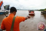 Petugas mengarahkan kapal yang membawa jasad Aling untuk sandar di Dermaga Feri Penyeberangan Rasau Jaya, Kabupaten Kubu Raya, Kalbar, Selasa (15/12). Aling adalah satu dari sepuluh penumpang yang dinyatakan hilang dalam peristiwa kecelakaan kapal Indo Kapuas Ekspress pada Minggu (13/12) pagi, dan berhasil ditemukan tim SAR gabungan di Perairan Desa Air Putih, Kabupaten Kubu Raya. ANTARA FOTO/Sheravim/jhw/15
