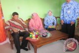 Wali Kota Kediri Abdullah Abu Bakar (kiri) mengunjungi warga penerima bantuan program perbaikan rumah di Kelurahan Burengan, Kecamatan Kota, Kediri, Jawa Timur, Kamis (17/12). Pemkot menganggarkan perbaikan rumah untuk 100 rumah warga pada 2015, dan akan dinaikkan menjadi 200 rumah pada 2016. Setiap rumah warga kurang mampu yang diperbaiki mendapatkan bantuan uang tunai Rp10 juta. Antara Jatim/Foto/Asmaul Chusna/15 