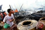 Warga dan petugas pemadam kebakaran menyiram air ke rumah kontrakan yang terbakar di Gang Damai 3, Jalan Harapan Jaya, Pontianak, Kalbar, Jumat (18/12). Dalam kebakaran yang menghanguskan tujuh rumah kontrakan tersebut, tidak terdapat korban jiwa dan belum diketahui penyebabnya. ANTARA FOTO/Sheravim/jhw/15

