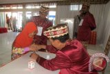 Petugas TPS membimbing seorang nenek mencelupkan jarinya ke botol tinta usai pencoblosan pada Pilkada serentak di TPS 5 Taman Budaya, Tanjungkarang Pusat, Kota Bandarlampung, Rabu (9/12/15).  (ANTARA FOTO/M.Tohamaksun).