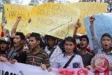 Mahasiswa yang tergabung dalam Solidaritas Peduli Simeulue (SOLUSI) Aceh, membawa poster dan spanduk saat berorasi di kantor Gubernur Aceh, Banda Aceh, Selasa (22/12). Mereka menuntut pemerintah membatalkan penempatan 1.100 KK transmigran dari luar Sumatera di Kabupaten Pulau Simeulue, Aceh, karena khawatir terjadi pembukaan lahan yang berdampak pada kerusakan hutan. ANTARA FOTO/Ampelsa/wdy/15