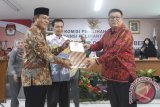 Ketua KPU Samahuddin Muharram menyerahkan surat keputusan  Gubernur kepada Sahbirin Noor dan Wakil Gubernur  Rudy Resnawan saat rapat penetapan di Sekretariat KPU Kalsel, Rabu (23/12). Sahbirin Noor dan Rudy Resnawan di tetapkan sebagai Gubernur dan Wakil Gubernur Kalsel periode 2016-2021 setelah meraih 739.588 suara pada Pilkada Kalsel 2015. Foto Antaranews Kalsel/Herry Murdy Hermawan 