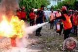 Sejumlah Lurah dan Kepala Desa mengikuti pelatihan penanggulangan bahaya kebakaran di pelataran parkir Balai Kota Ambon, Maluku, Selasa (22/12). Latihan yang diikuti seluruh Lurah dan Kepala Desa se-Kota Ambon tersebut dilakukan untuk meningkatkan kesiapsiagaan seluruh jajaran Pemerintah Kota (Pemkot) Ambon dalam menghadapi situasi sebenarnya. ANTARA FOTO/Izaac Mulyawan/kye/15.