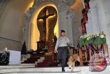 Anggota Brimob Polda Bali mengarahkan anjing pelacak saat sterilisasi kebaktian malam Natal di Gereja Katedral, Denpasar, Bali, Jumat (24/12). Sebanyak 253 Gereja yang tersebar di Kota Denpasar dan 8 kabupaten lainnya di Bali menjadi pusat kebaktian Natal tahun ini di Pulau Dewata. FOTO ANTARA/Nyoman Budhiana/i018/2015.