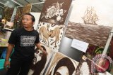 Morris Siregar memperlihatkan hasil lukisannya yang terbuat dari bahan kopi saat pameran Dinas UMKM dan Koperasi Kota Medan di Plaza Medan Fair baru-baru ini. Lukisan dari kopi tersebut dijual bervariasi mulai dari harga Rp 300 ribu hingga Rp 1 juta tergantung tingkat kerumitan. 
