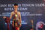 Seorang model mengenakan gaun tradisional etnik Ulos dan Songket Sumut pada peluncuran Rumah Tenun Ulos di Medan, Sumatera Utara, Kamis (10/12). Desain gaun etnik dengan seratus bermotif kain Ulos dan Songket tersebut tercatat dalam rekor Museum Rekor Indonesia (MURI). ANTARA FOTO/Septianda Perdana
