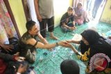 Warga mengunjungi pimpinan kelompok sipil bersenjata Nurdin alias Din Minimi (kiri) di Desa Ladang Baro, Kecamatan Julok, Aceh Timur, Aceh, Selasa (29/12). Kelompok bersenjata sepakat berdamai setelah 4 butir permintaan mereka dipenuhi oleh Pemerintah dan mereka juga menyerahkan 15 pucuk senjata api laras panjang beserta amunisi satu karung kepada pihak keamanan. ANTARA FOTO/Syifa Yulinnas/wdy/15.