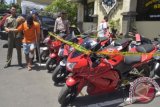 Polisi membawa tersangka pencuri sepeda motor KGAS (kedua kiri) seusai rilis tersangka dan barang bukti di Mapolres Badung, Selasa (29/12). Pelaku merupakan tahanan Polres Gianyar yang sempat melarikan diri dan kembali melakukan pencurian hingga 25 kali di Bali tapi berhasil ditangkap kembali beserta tujuh unit sepeda motor hasil curian senilai Rp450 juta. ANTARA FOTO/Wira Suryantala/wdy/15.
