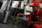 Petugas mengecek kualitas bahan bakar jenis premium di SPBU kawasan Jalan Gatot Subroto, Jakarta, Selasa (29/12). PT Pertamina Persero menjamin ketersediaan bahan bakar jelang libur tahun baru yang diprediksi meningkat 10-15 persen, dan mengerahkan sebanyak 2.580 mobil tanki bahan bakar minyak (BBM) untuk memastikan ketersediaan BBM di wilayah yang dimungkinkan terjadi penumpukan kendaraan. ANTARA FOTO/Puspa Perwitasari/nz/15