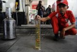 Petugas mengecek kualitas bahan bakar jenis premium di SPBU kawasan Jalan Gatot Subroto, Jakarta, Selasa (29/12). PT Pertamina Persero menjamin ketersediaan bahan bakar jelang libur tahun baru yang diprediksi meningkat 10-15 persen, dan mengerahkan sebanyak 2.580 mobil tanki bahan bakar minyak (BBM) untuk memastikan ketersediaan BBM di wilayah yang dimungkinkan terjadi penumpukan kendaraan. ANTARA FOTO/Puspa Perwitasari/nz/15